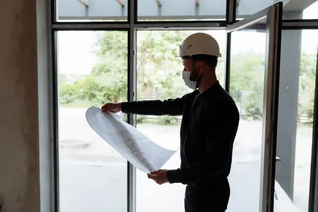 Worker reading floor plans for property