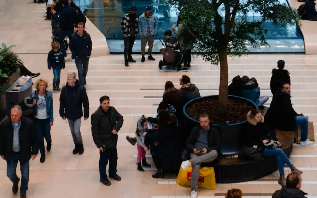 People walking around and sitting in a busy shopping centre